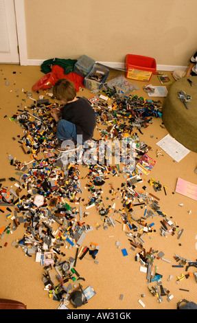 Cinque anni di vecchio ragazzo giocando con i blocchi di Lego a casa sul pavimento Foto Stock