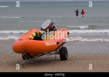 Due nuotatori sfidando il freddo in mare le imbarcazioni di salvataggio gonfiabile è in standby Foto Stock