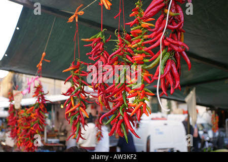 Rosso e verde e arancione il peperoncino di riagganciare per la vendita su un tipico Roma mercato di frutta e verdura in stallo, Italia Europa Foto Stock