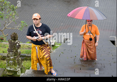 Persone che trasportano gli ombrelli a passi fino alla pura Tempio Besakih Bali Indonesia Foto Stock