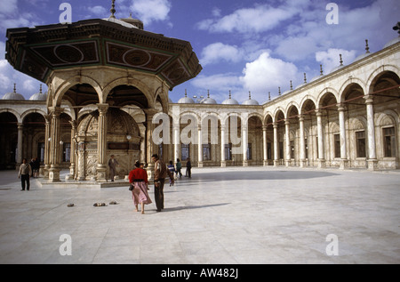 Persone in alabastro Cortile della moschea di Mohammed Ali in cittadella nel Cairo Islamico di non indossare delle scarpe Foto Stock