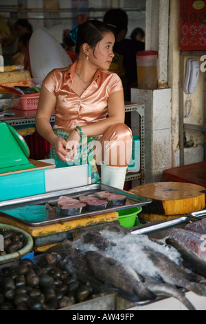 Una giovane donna attende i clienti in un mercato del pesce al di fuori del mercato di Ben Thanh, HO CHI MINH CITY SAIGON VIETNAM Foto Stock