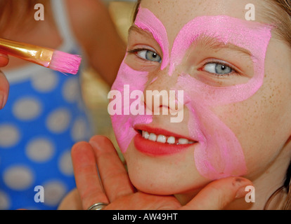 Ragazza ottenendo faccia dipinta Foto Stock