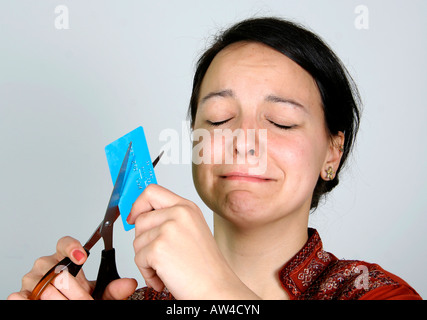 Signora taglio la sua carta di credito nella disperazione Foto Stock