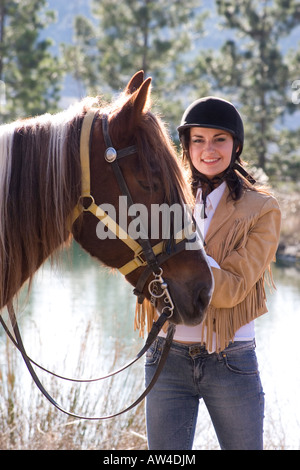 Giovane e bella modello in posa con il suo cavallo Foto Stock