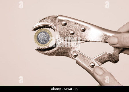 Esercitare pressione sul pound mani con la chiave la spremitura di una due pound coin Foto Stock