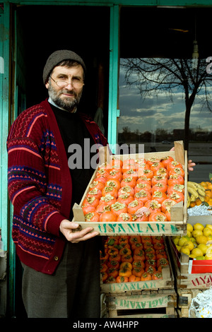 Un negozio di frutta proprietario tenendo un vassoio di prodotti freschi al di fuori del suo negozio in Turchia. Foto Stock