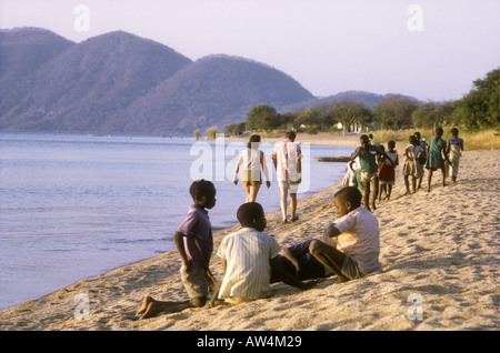 I bambini africani e turisti bianco sulla riva di Monkey Bay all'estremità meridionale del lago Malawi Sud Africa Foto Stock
