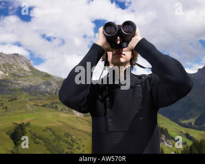 Uomo che guarda attraverso il suo binocolo. Foto Stock