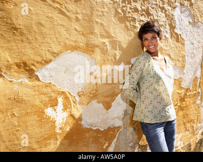 La donna in piedi contro un muro. Foto Stock