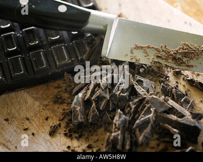 Un blocco di cioccolato tritato su una tavola di legno Foto Stock