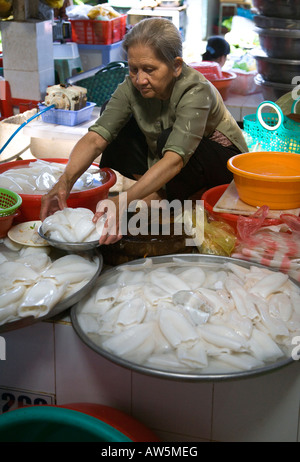 Una donna vietnamita imposta display grandi di calamari all'interno del mercato di Ben Thanh, HO CHI MINH CITY SAIGON VIETNAM Foto Stock