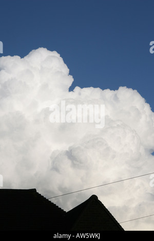 White cumulo nimbus nuvole edificio su stagliano tetto Foto Stock