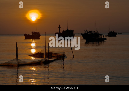 Tramonto su barche da pesca al largo della costa di BAI DAI BEACH PHU QUOC ISLAND IN VIETNAM Foto Stock