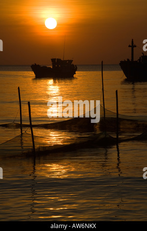 Tramonto su barche da pesca al largo della costa di BAI DAI BEACH PHU QUOC ISLAND IN VIETNAM Foto Stock