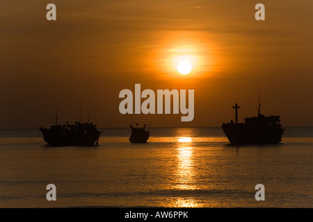 Tramonto su barche da pesca al largo della costa di BAI DAI BEACH PHU QUOC ISLAND IN VIETNAM Foto Stock