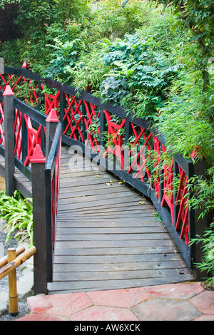 Rosso e nero dipinto di ponte di legno in un giardino in stile giapponese Foto Stock