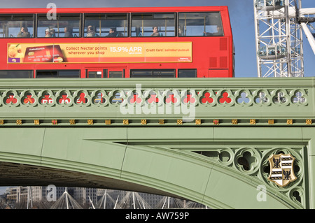 Red double decker bus crossing Westminster Bridge with partial view of London Eye  London England UK Foto Stock