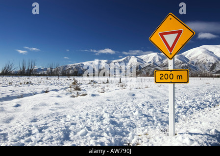 Un cartello stradale indica un bivio davanti al quale il traffico deve dare modo o resa al traffico sull'altra strada. Foto Stock