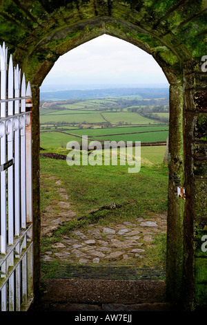 Guardando fuori del gated portale della chiesa di San Michele sul Brent Tor con il paesaggio del Parco Nazionale di Dartmoor oltre Foto Stock