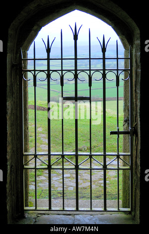 Guardando fuori del gated portale della chiesa di San Michele sul Brent Tor con il paesaggio del Parco Nazionale di Dartmoor oltre Foto Stock