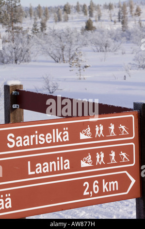 Alberi e la pista di sci segno nel Urho Kekkosen Parco Nazionale vicino a Saariselka il nord della Finlandia Foto Stock
