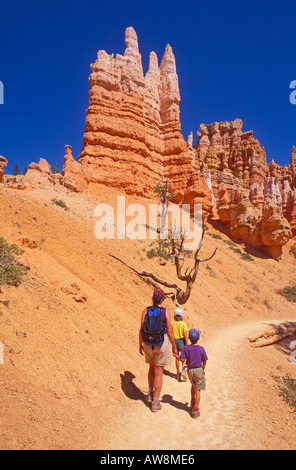 Madre e bambini trekking sotto guglie di roccia sulla Queen's Garden Trail di Bryce Canyon National Park nello Utah Foto Stock