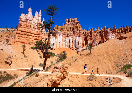 Madre e bambini (età 4 & 8) Trekking sotto guglie di roccia sul Queens Garden Trail di Bryce Canyon National Park nello Utah Foto Stock