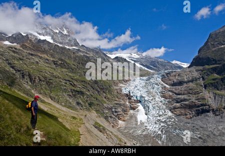Tourist escursionista guardando il ghiacciaio delle Alpi svizzere Foto Stock