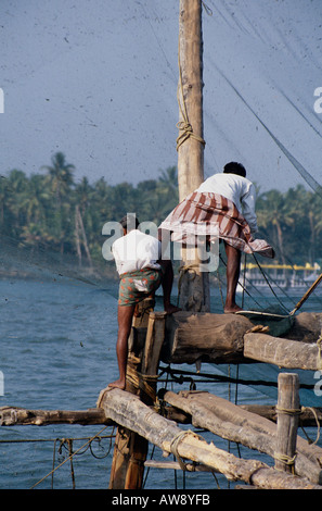 I pescatori operanti un cinese rete da pesca, Fort Cochin, Kerala, nell India meridionale Foto Stock