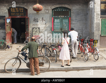 Persone Affitto di biciclette dal negozio nel Patrimonio Mondiale UNESCO città di Pingyao, Shaanxi Foto Stock