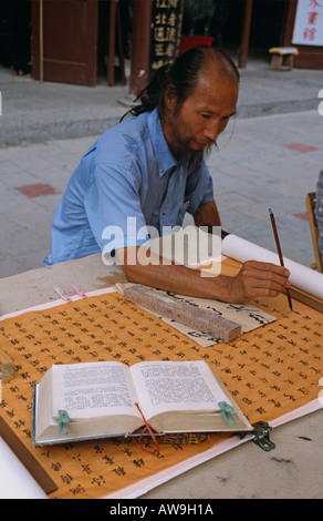 L'uomo dimostrando la calligrafia in un mercato locale, Xian, Cina Foto Stock