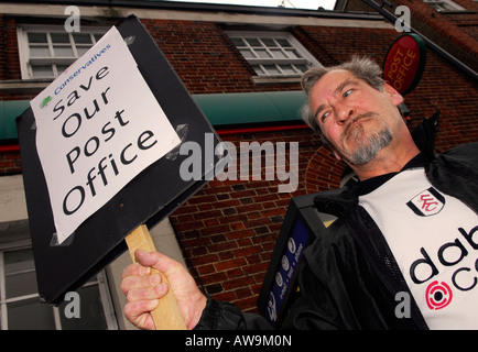 61 anno vecchio protestando per eventuale chiusura del suo ufficio postale locale High Street New Malden Surrey Foto Stock