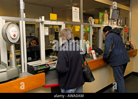 I clienti che utilizzano il proprio ufficio postale locale, High Street, New Malden, Surrey, Regno Unito. Foto Stock