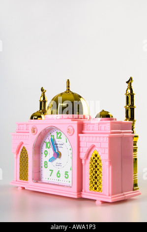 Plastica rosa sveglia nella forma di una moschea. Girato su uno sfondo bianco. Essa svolge anche una mattina e giorno chant - Azar. Foto Stock
