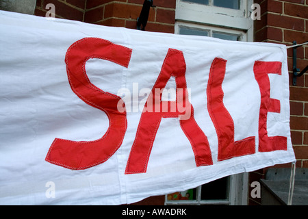 Accozzaglia Vendita banner al di fuori village hall di bianco e rosso Foto Stock