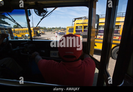 Lasciando il bus cantiere nel mercato di Masaya, tessitura attraverso parcheggiato convertito scuolabus Foto Stock