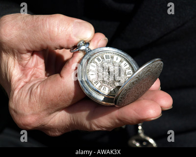 Vecchio orologio essendo mantenuta aperta per vedere il tempo da una mano d'uomo Foto Stock