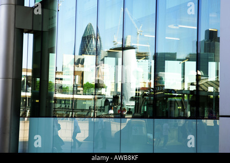 Vista riflessa di HMS Belfast e Swiss Re Building (Gerkin) riflesso nell'edificio degli uffici di Londra, Regno Unito Foto Stock