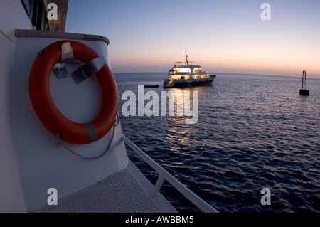 Crociere navi ormeggiate lungo il reef al tramonto in Mar Rosso, Egitto. Foto Stock