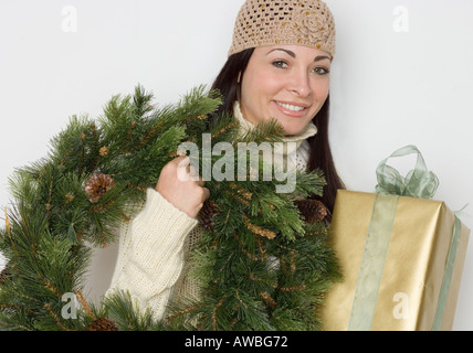 Donna che mantiene ghirlanda di vacanza e presente Foto Stock