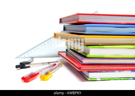 Penne righelli bussola e pila di libri colorati isolato su bianco Foto Stock