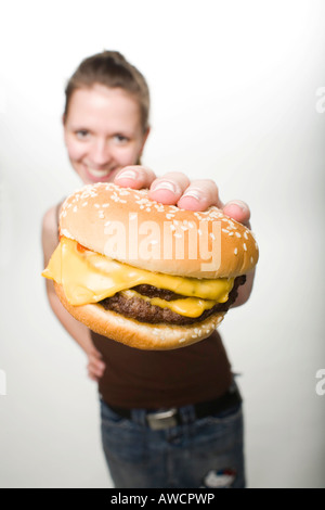 Donna che mantiene un cheeseburger Foto Stock