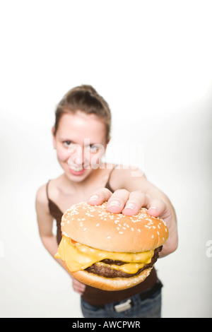 Donna che mantiene un cheeseburger Foto Stock