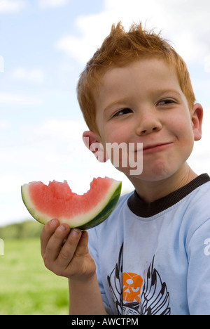 Ragazzo mangia un cocomero Foto Stock