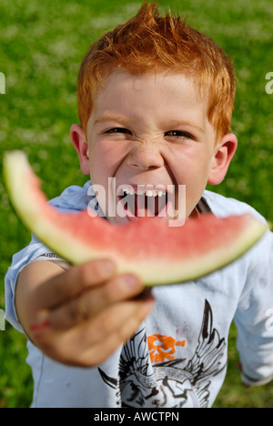 Ragazzo mangia un cocomero Foto Stock