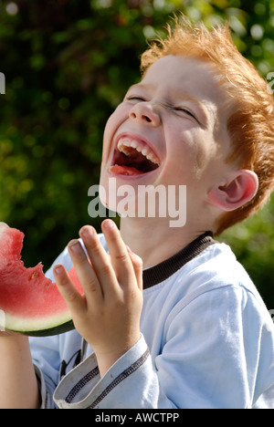 Ragazzo mangia un cocomero Foto Stock