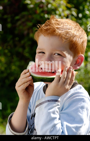Ragazzo mangia un cocomero Foto Stock