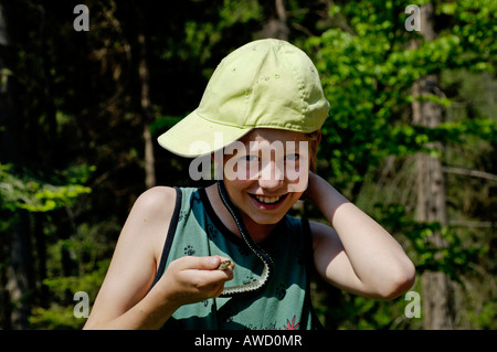 Ragazzo di undici anni tenendo un Blindworm o rallentare il worm (Anguis fragilis) intorno al suo collo Foto Stock