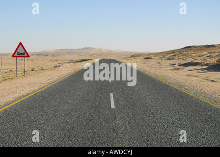 Cartello stradale di avvertimento di sabbie di spazzamento su una autostrada vicino Luederitz, Namibia, Africa Foto Stock